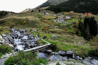 Scenic view of stream by mountains against sky