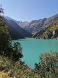 Scenic view of lake by mountains against sky