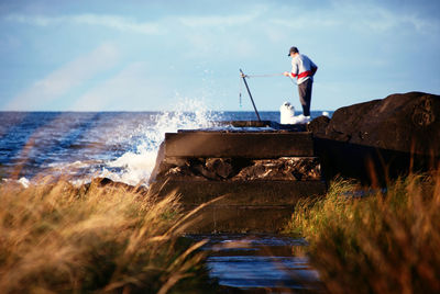 Man standing by sea against sky