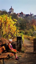 Woman sitting on bench in town