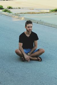 Young man sitting on street