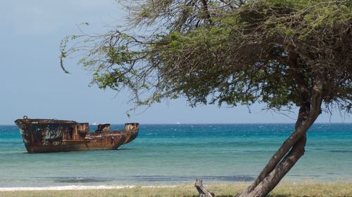 Abandoned boat on beach against clear sky