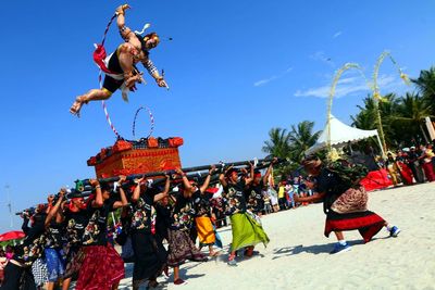 People on clothesline against clear blue sky