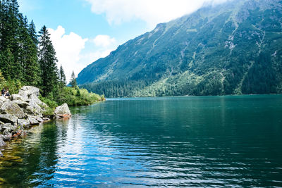 Scenic view of lake by mountains against sky