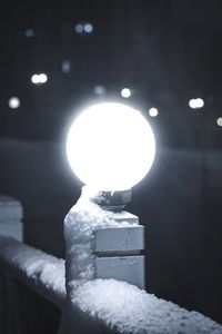 Close-up of illuminated lamp in snow