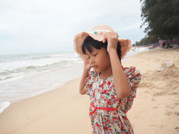 Happy girl on beach against sky