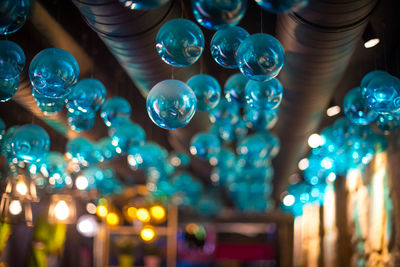 Low angle view of illuminated lights hanging on ceiling