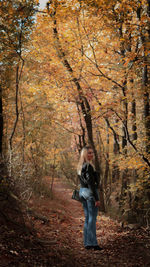 Full length of woman standing in forest during autumn