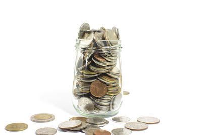 Close-up of coins in container against white background