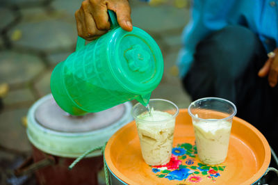 Close-up of hand holding drink on table