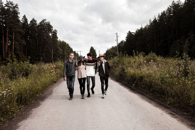 Young friends walking on countryside road