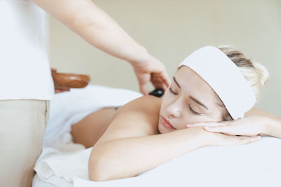 Midsection of woman lying on bed