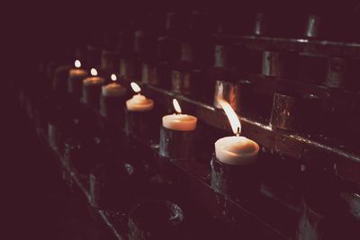 Close-up of lit candles in row