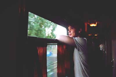 Man looking through window in passenger train