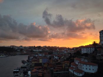 Townscape against cloudy sky at sunset