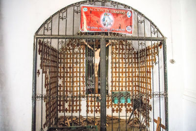 Close-up of an animal cage on metal wall