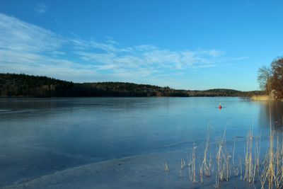 Scenic view of lake against blue sky