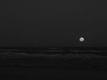 Scenic view of sea against moon at night