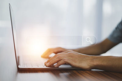 Digital composite image of businessman using laptop