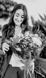 Portrait of young woman holding bouquet