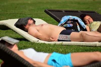 Midsection of man sleeping on grass