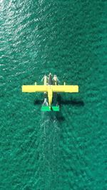 High angle view of men floating on sea