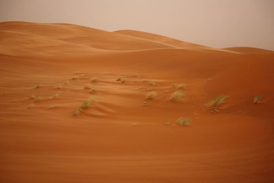 Sand dunes in desert against sky