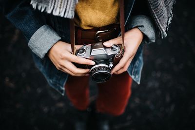 Midsection of man photographing camera
