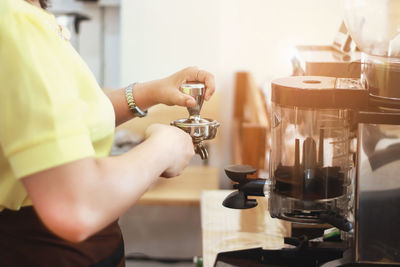 Midsection of woman having coffee at cafe