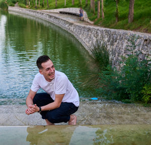 Portrait of young man standing by lake