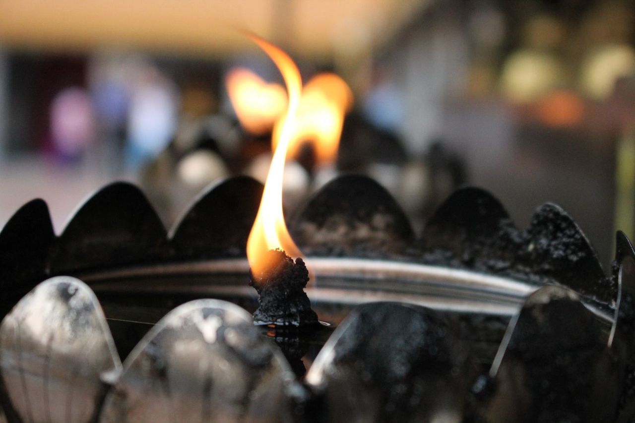 flame, burning, heat - temperature, focus on foreground, fire - natural phenomenon, close-up, glowing, selective focus, candle, indoors, lit, illuminated, fire, orange color, spirituality, metal, no people, religion, in a row, place of worship