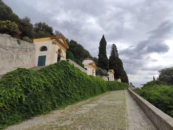 Footpath amidst buildings against sky