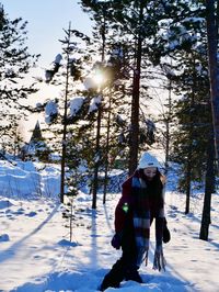 Woman standing on snow covered field during winter