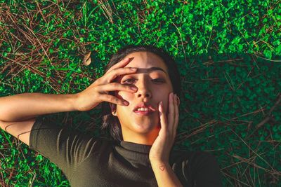 Portrait of young woman lying on grassy field