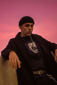 Portrait of young man looking away against sky during sunset