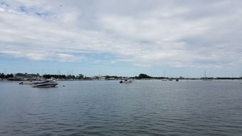 Sailboats moored on sea against sky