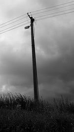 Low angle view of windmill against cloudy sky