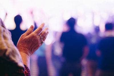 Close-up of wrinkled hand over blurred background