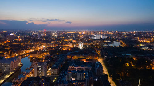 High angle view of illuminated city against sky at dusk