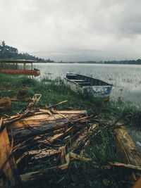 Abandoned boats moored in lake against sky