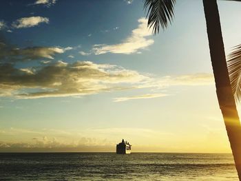 Silhouette sailboat in sea against sky during sunset