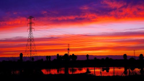 Silhouette of power lines against dramatic sky
