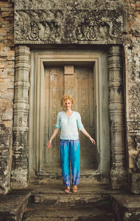 Smiling mid adult woman standing outside ankor wat temple