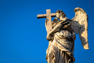 Low angle view of statue against blue sky