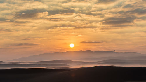 Scenic view of silhouette mountains against sky during sunset