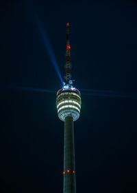 Stuttgart television tower against night sky with stars and light beams