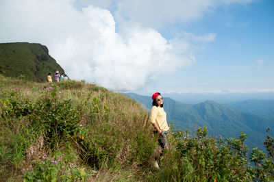 Mid adult woman standing on mountain against sky