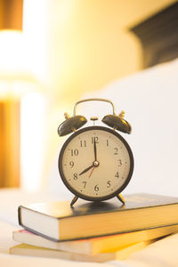 Close-up of clock on table against wall