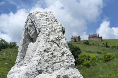 View of rock formation on field against sky