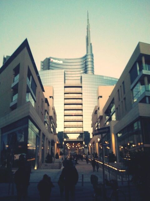 architecture, building exterior, built structure, city, city life, street, clear sky, large group of people, building, sky, tall - high, tower, skyscraper, city street, walking, incidental people, office building, travel destinations, men